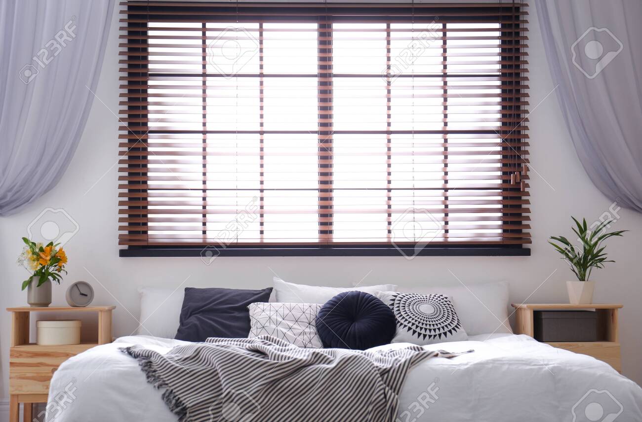 Modern Room Interior With Comfortable Double Bed And Window Blinds