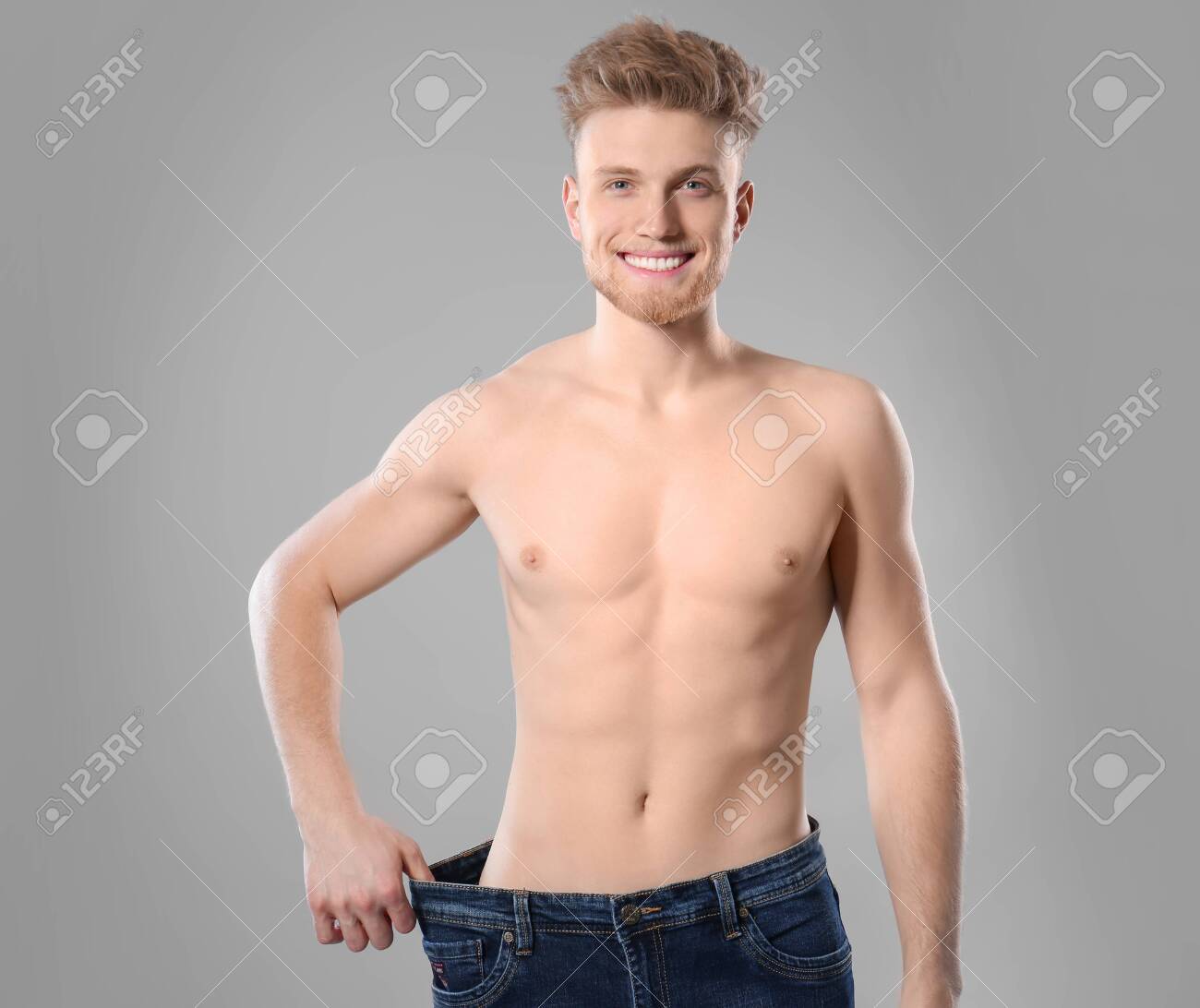 Young Man With Slim Body In Old Big Size Jeans On Grey Stock Photo Picture And Royalty Free Image Image