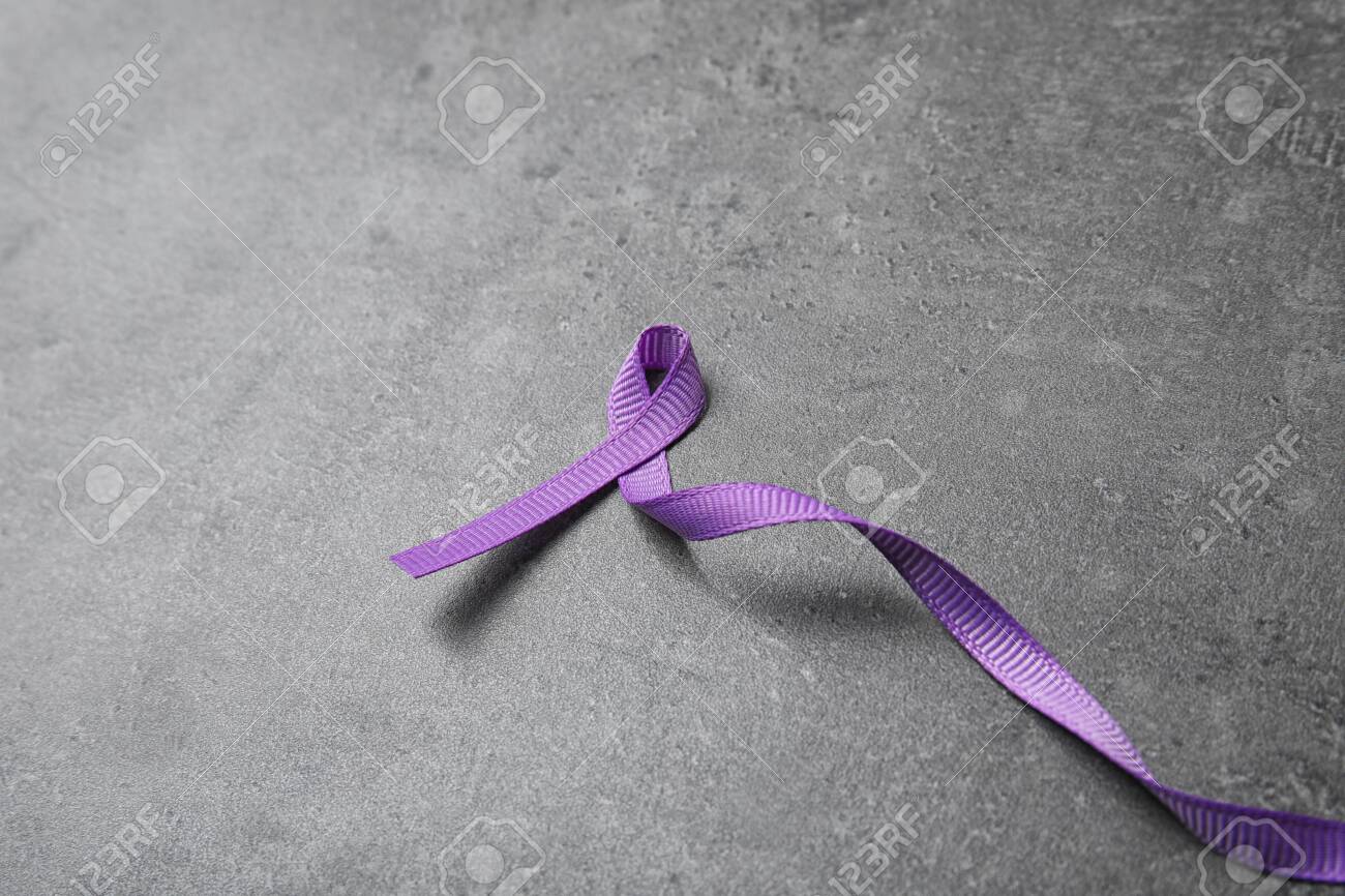 Purple ribbon on grey stone background, space for text. Domestic violence awareness - 126053165 Purple ribbon on grey stone background, space for text. Domestic violence awareness - 126053165