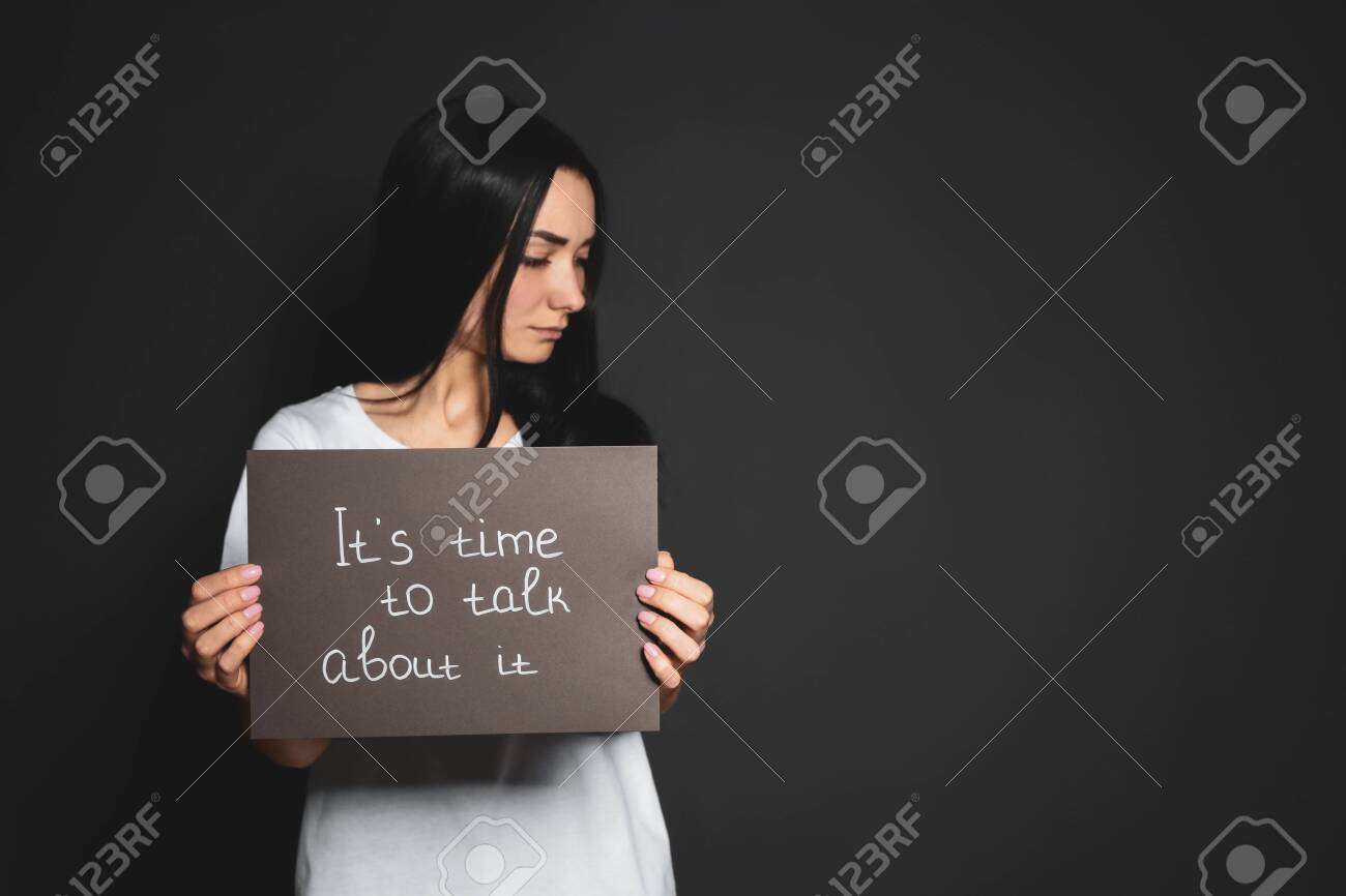 Young woman holding card with words IT'S TIME TO TALK ABOUT IT against dark background. Space for text - 133227134 Young woman holding card with words IT'S TIME TO TALK ABOUT IT against dark background. Space for text - 133227134