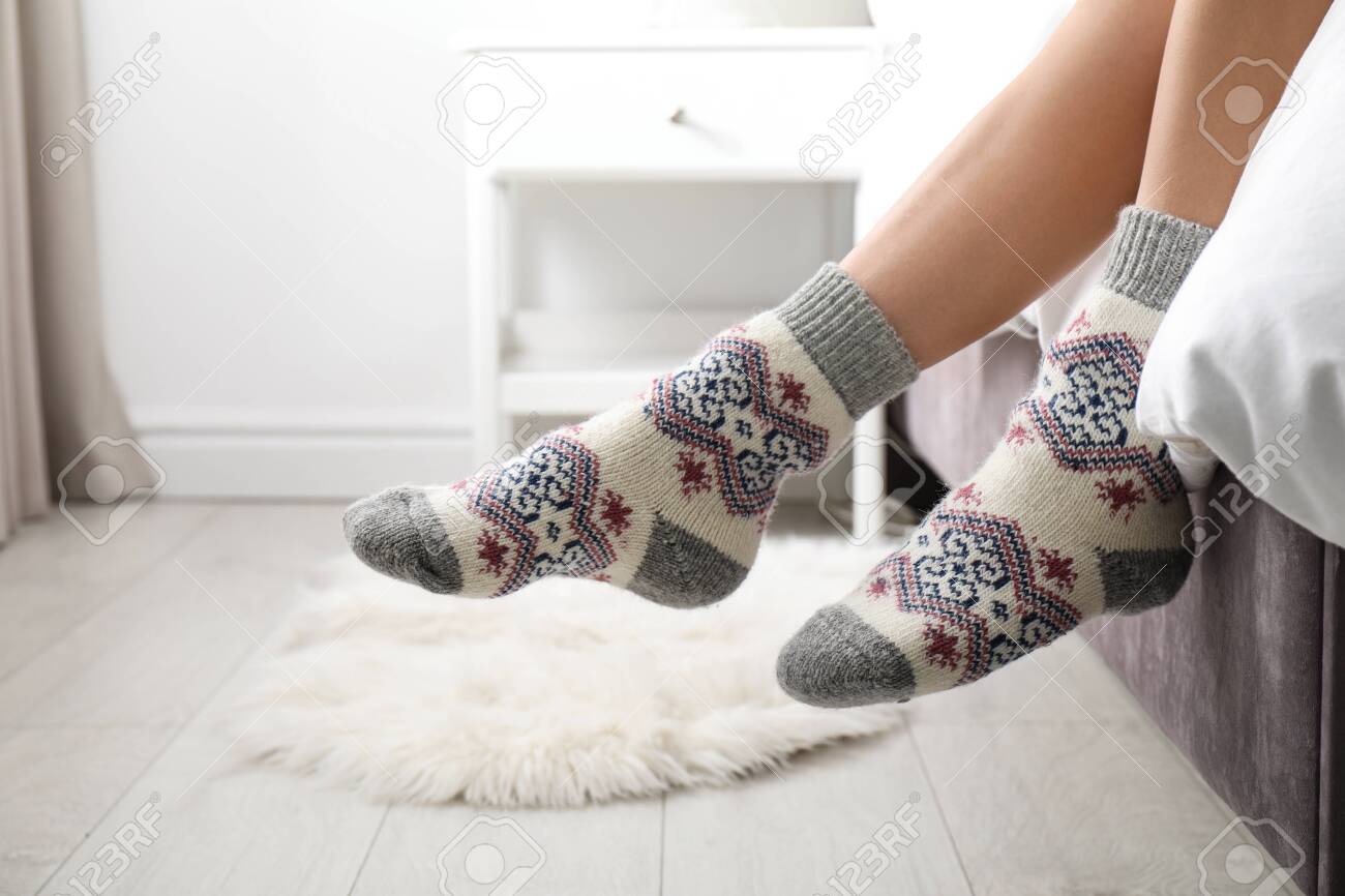 Woman wearing knitted socks on bed indoors, closeup. Warm clothes - 133040645 Woman wearing knitted socks on bed indoors, closeup. Warm clothes - 133040645
