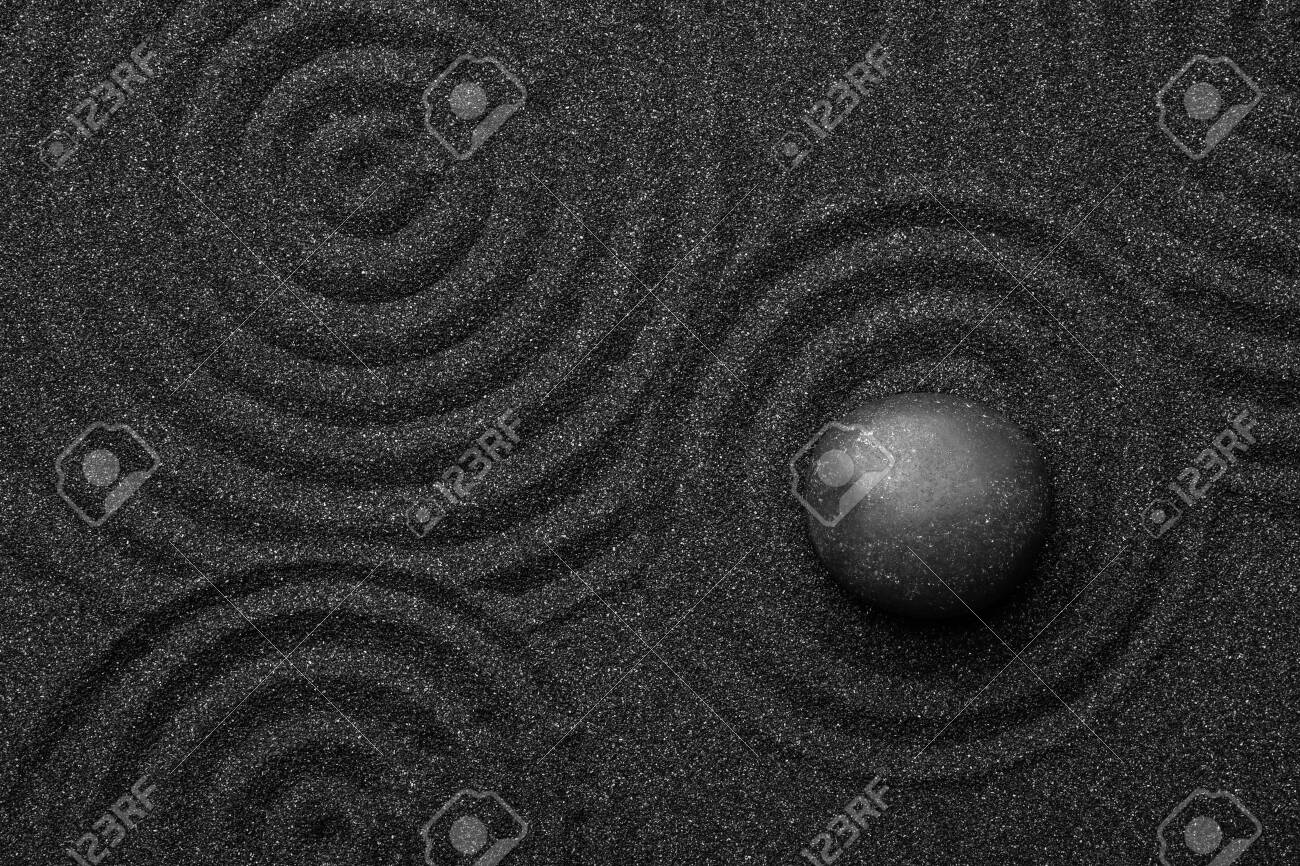Black sand with stone and beautiful pattern, top view. Zen concept - 135951092 Black sand with stone and beautiful pattern, top view. Zen concept - 135951092