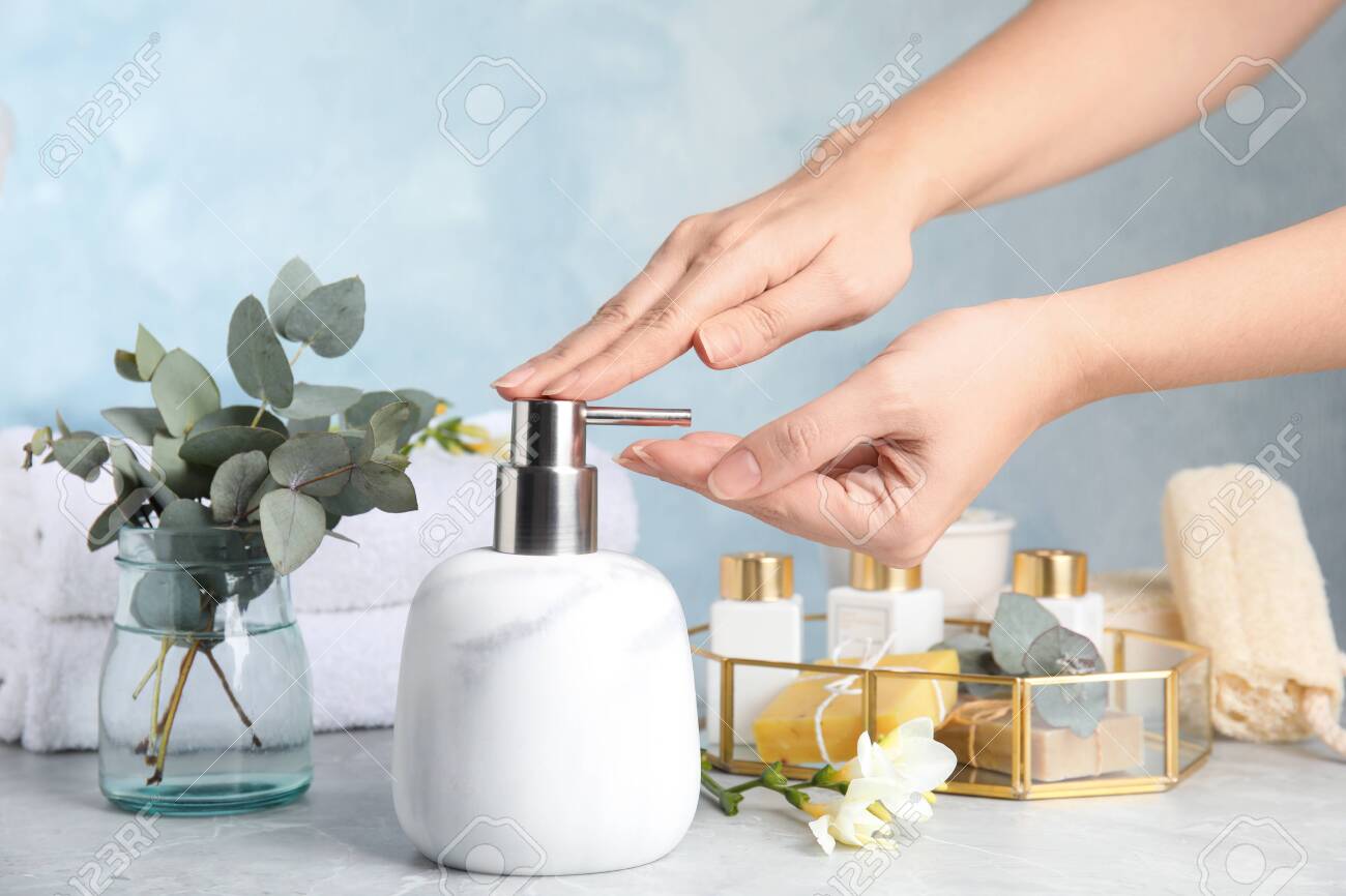 Woman using soap dispenser indoors, closeup view - 138730744 Woman using soap dispenser indoors, closeup view - 138730744