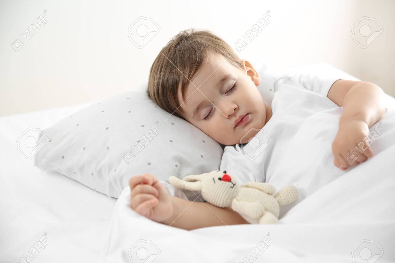 Cute little baby sleeping with toy at home. Bedtime - 140022613 Cute little baby sleeping with toy at home. Bedtime - 140022613