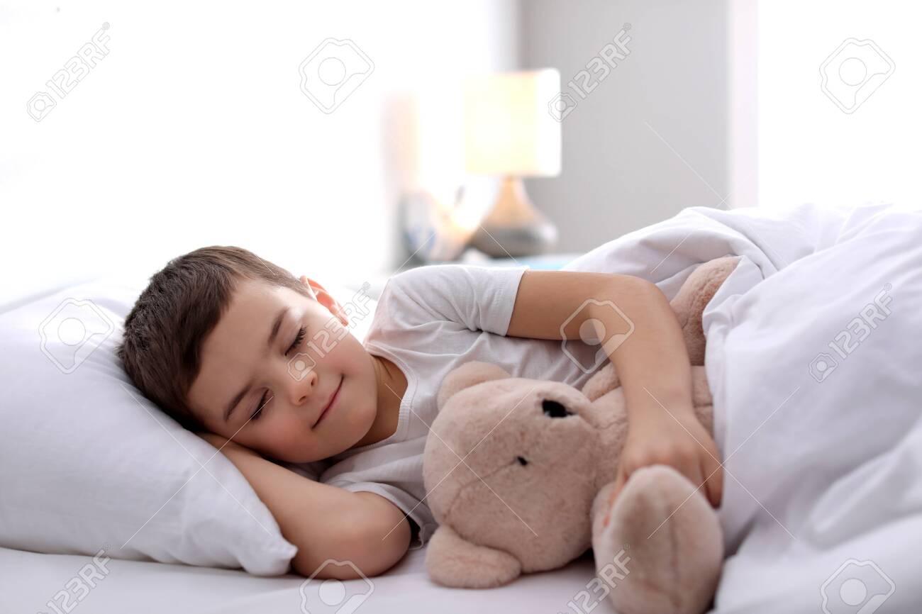 Little boy sleeping with teddy bear at home. Bedtime - 140894494 Little boy sleeping with teddy bear at home. Bedtime - 140894494
