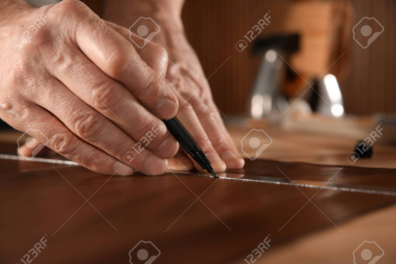 Man working with piece of leather in workshop, closeup - 140834195 Man working with piece of leather in workshop, closeup - 140834195