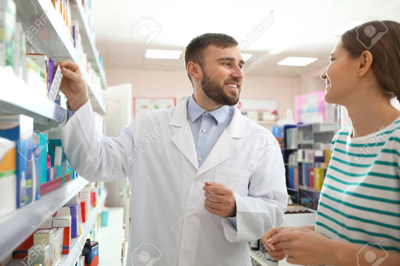 Professional pharmacist working with customer in modern drugstore - 141112001 Professional pharmacist working with customer in modern drugstore - 141112001