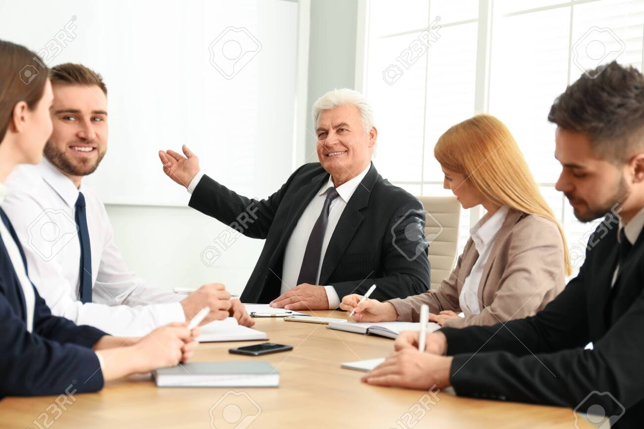 Senior business trainer working with people in office - 141625538 Senior business trainer working with people in office - 141625538