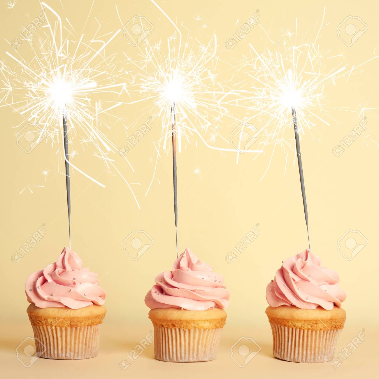 Download Birthday Cupcakes With Sparklers On Light Yellow Background Stock Photo Picture And Royalty Free Image Image 141971344 PSD Mockup Templates