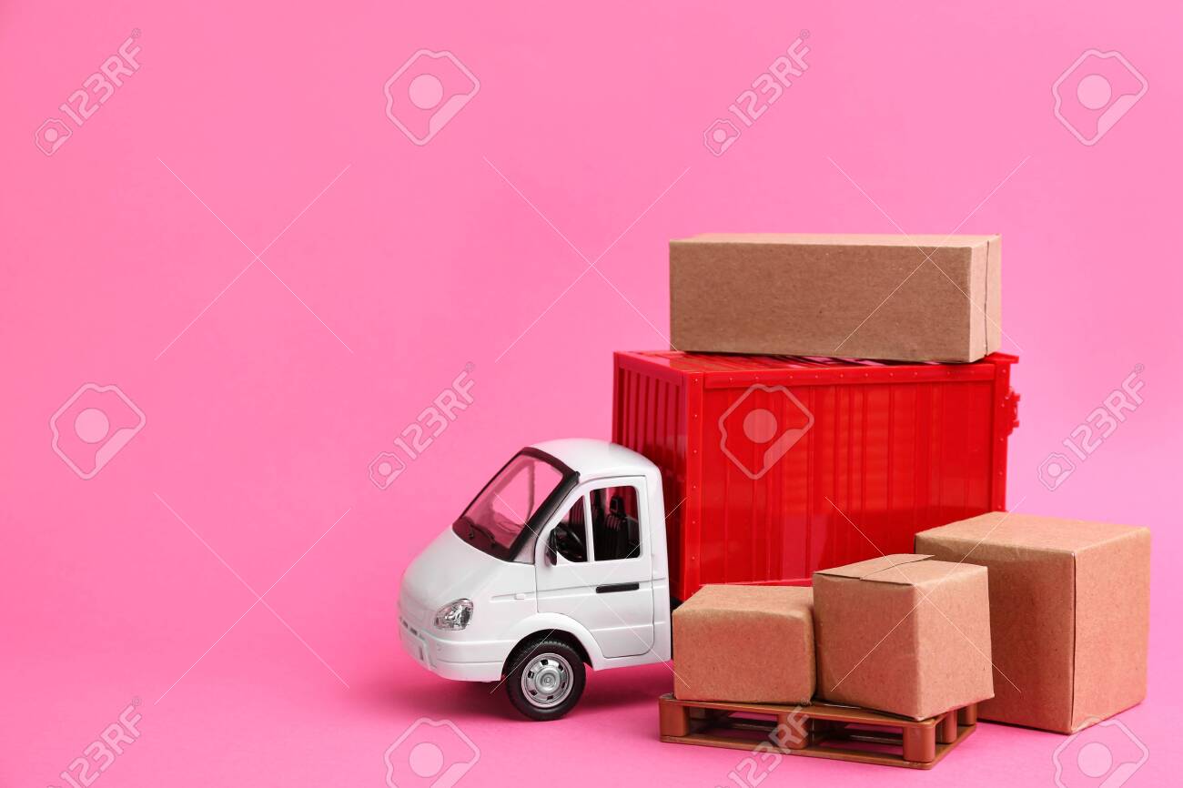 Truck model and carton boxes on pink background, space for text. Courier service - 142280570 Truck model and carton boxes on pink background, space for text. Courier service - 142280570