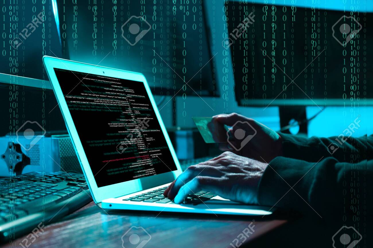 Cyber criminal with credit card hacking system at table, digital binary code on background - 143198616 Cyber criminal with credit card hacking system at table, digital binary code on background - 143198616