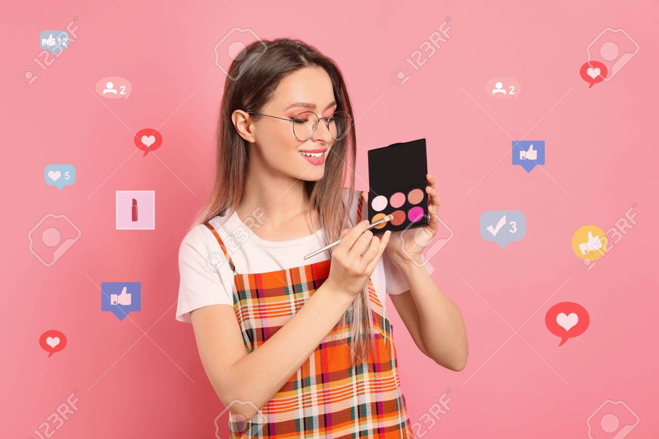 Beauty blogger with brush and eyeshadow palette on pink background - 145278986 Beauty blogger with brush and eyeshadow palette on pink background - 145278986