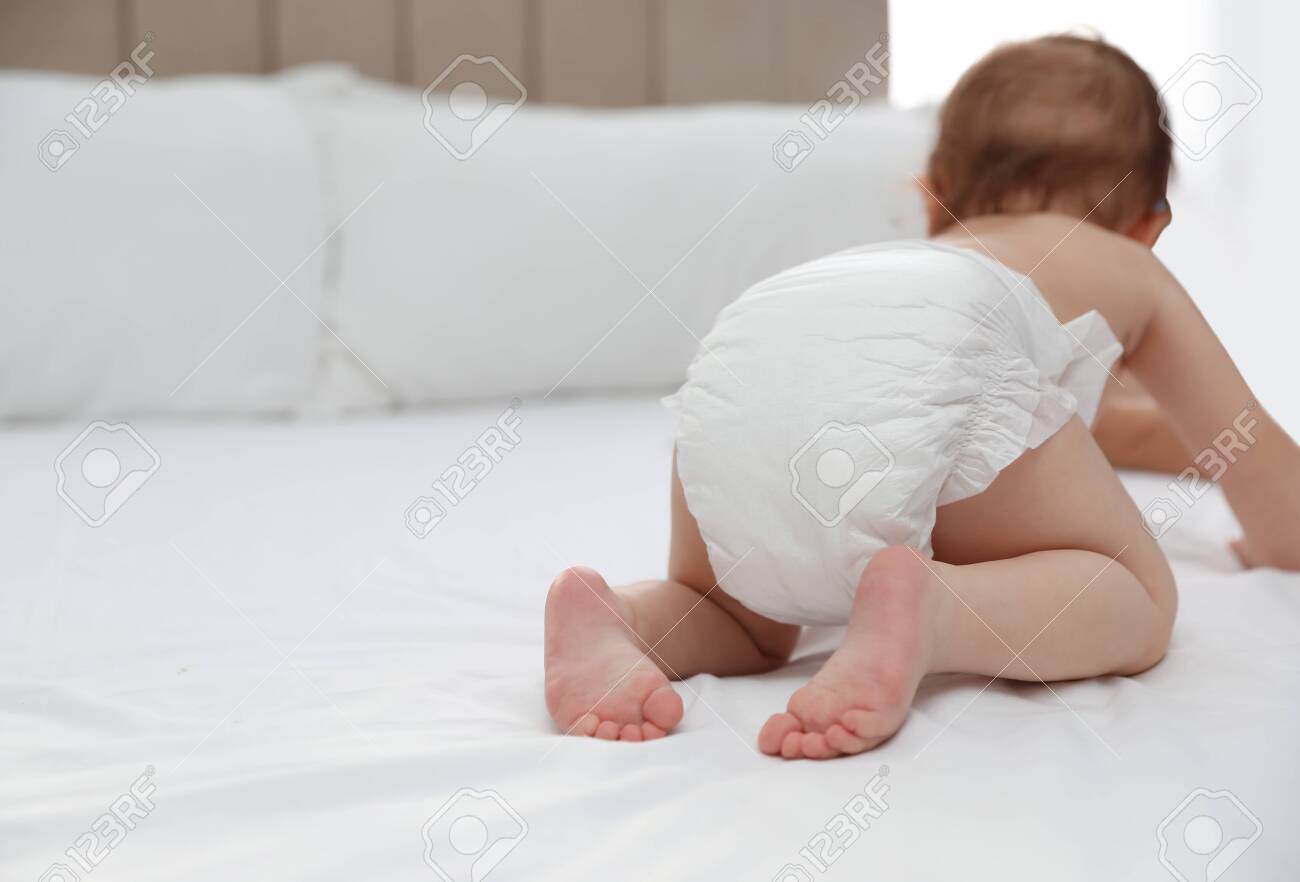 Cute little baby in diaper on bed, closeup. Space for text - 145317929 Cute little baby in diaper on bed, closeup. Space for text - 145317929