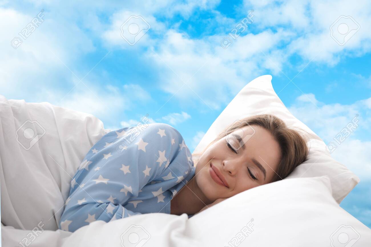 Young woman sleeping in bed. Blue sky on background - 148921141 Young woman sleeping in bed. Blue sky on background - 148921141