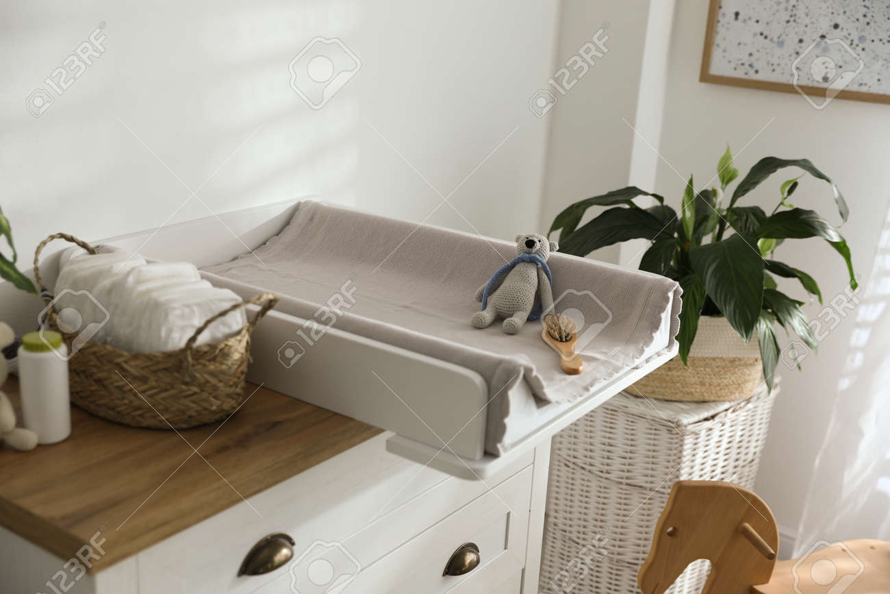 Chest of drawers with changing pad and tray in nursery. Baby room interior design - 155887567 Chest of drawers with changing pad and tray in nursery. Baby room interior design - 155887567