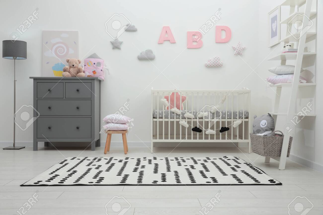 Cute baby room interior with crib and chest of drawers near white wall - 155373231 Cute baby room interior with crib and chest of drawers near white wall - 155373231