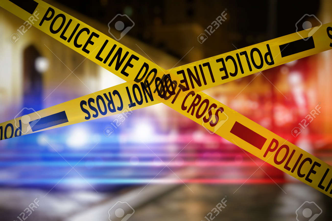 Yellow law enforcement tape isolating crime scene. Blurred view of city street, toned in red and blue police car lights - 158920409 Yellow law enforcement tape isolating crime scene. Blurred view of city street, toned in red and blue police car lights - 158920409