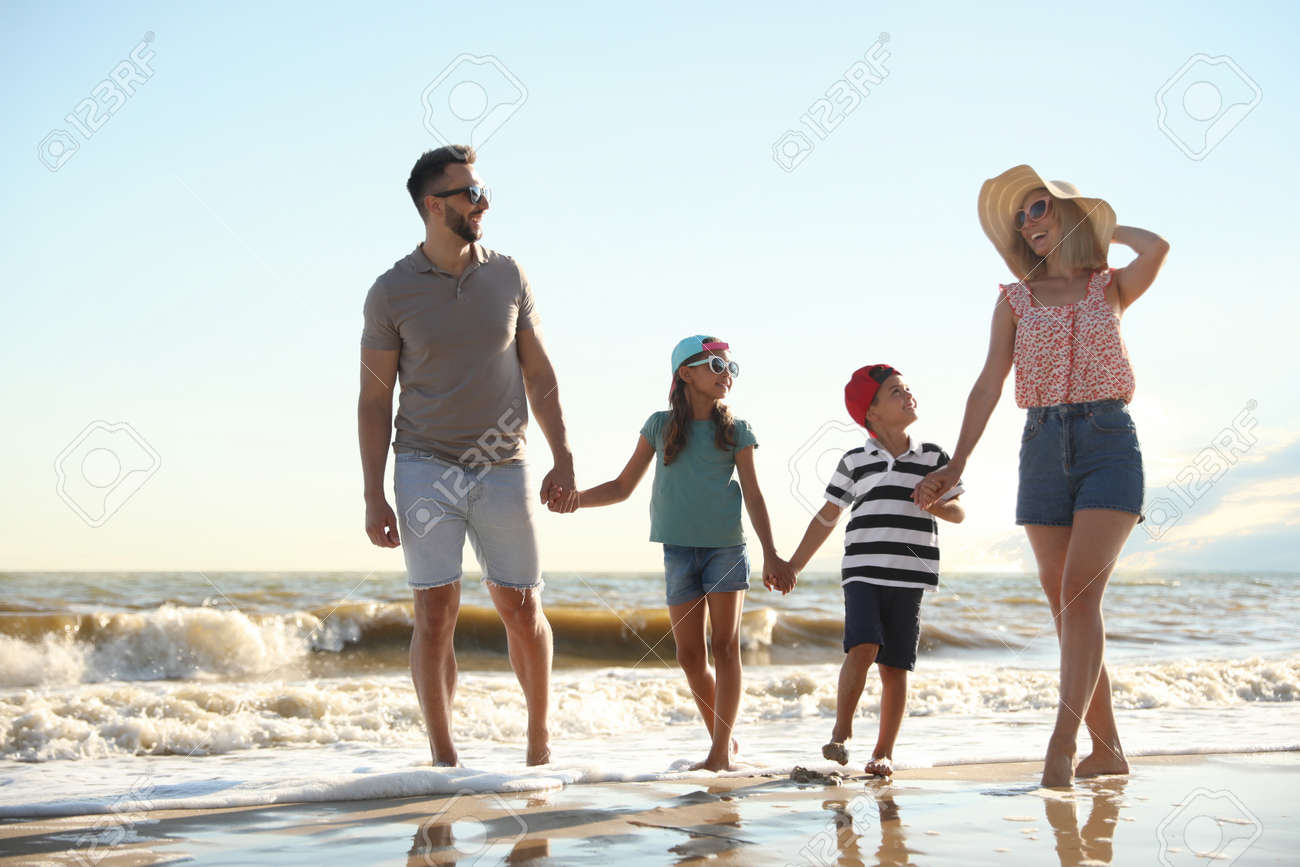 Happy family walking on sandy beach near sea - 159301778 Happy family walking on sandy beach near sea - 159301778