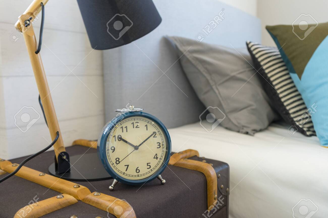 Blue Alarm Clock Standing On Nightstand Beside Bed In Interior Stock Photo Picture And Royalty Free Image Image 130201722