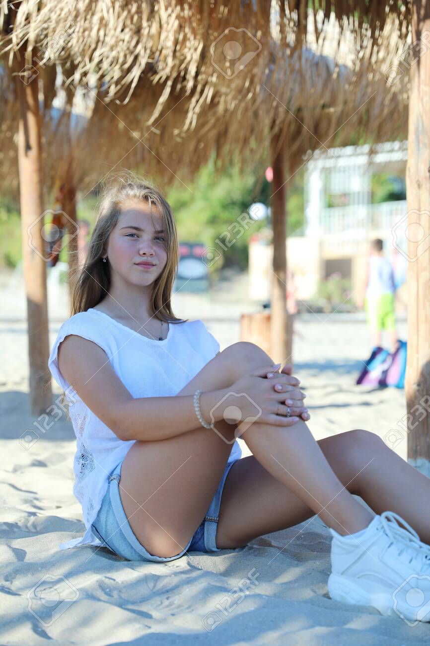 Cute Blonde Young Girl Sitting On The White Sand Beach Under A Straw  Parasol In Sveti Vlas, Bulgaria Stock Photo, Picture and Royalty Free  Image. Image 137364085., image size:866x1300