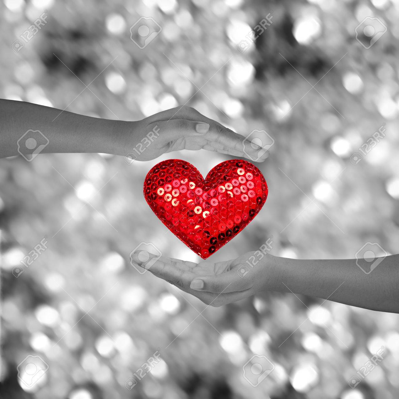 Two Hands Holding Red Heart Shap On Black And White Bokeh Background Stock  Photo, Picture And Royalty Free Image. Image 37760205.