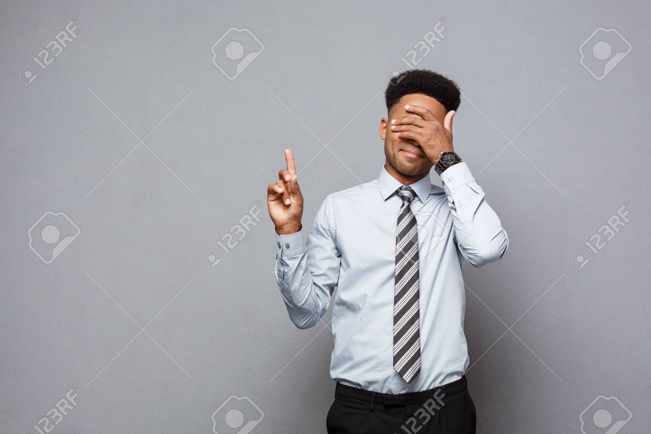 ビジネスコンセプト グレーの背景の上に横に自信を持って思慮深い若いアフリカ系アメリカ人の指差し指 の写真素材 画像素材 Image