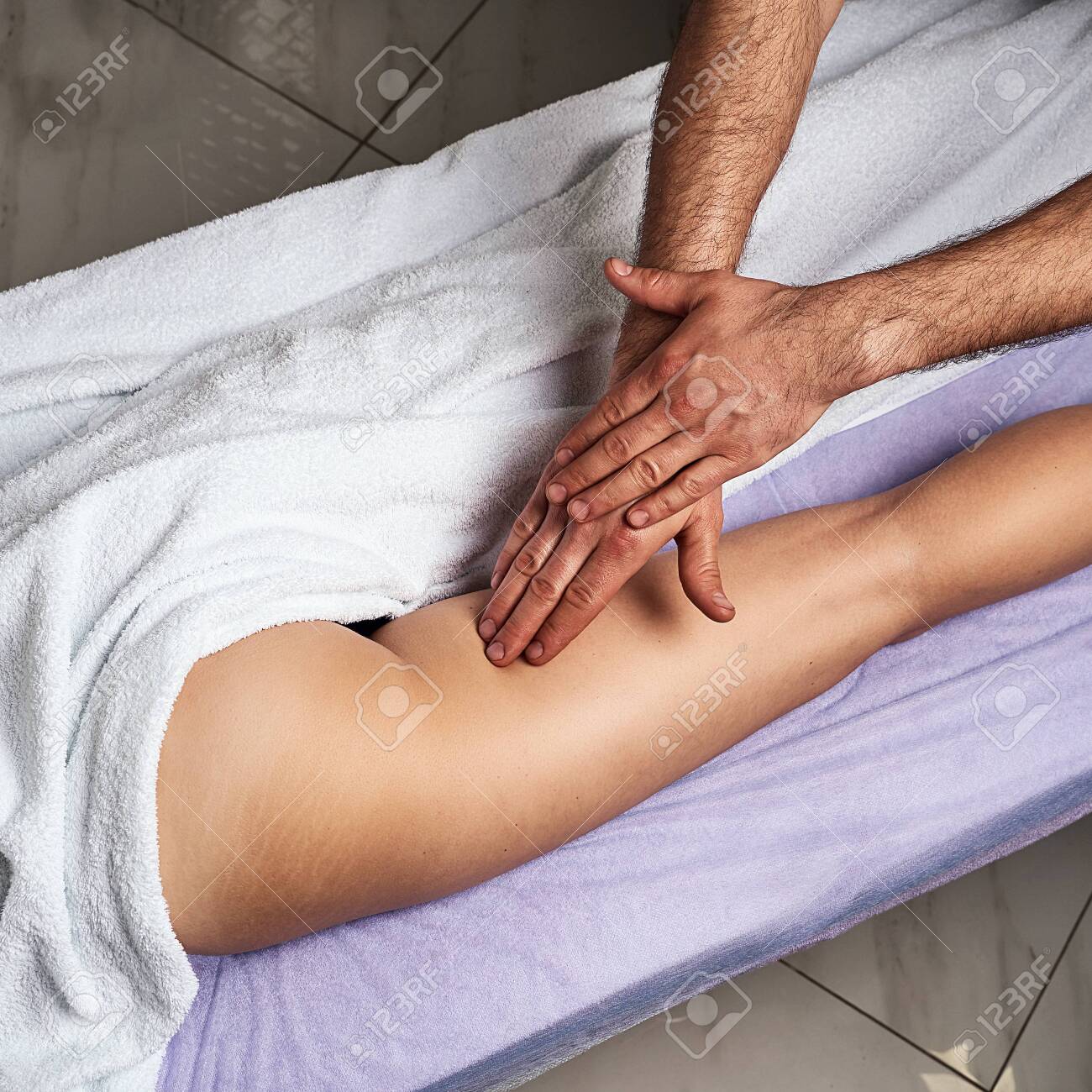 Male Masseur Doing Massage On Leg Thigh Of Beautiful Naked Woman Body In  The Spa Salon. Beauty Treatment Concept. Stock Photo, Picture and Royalty  Free Image. Image 143476937.