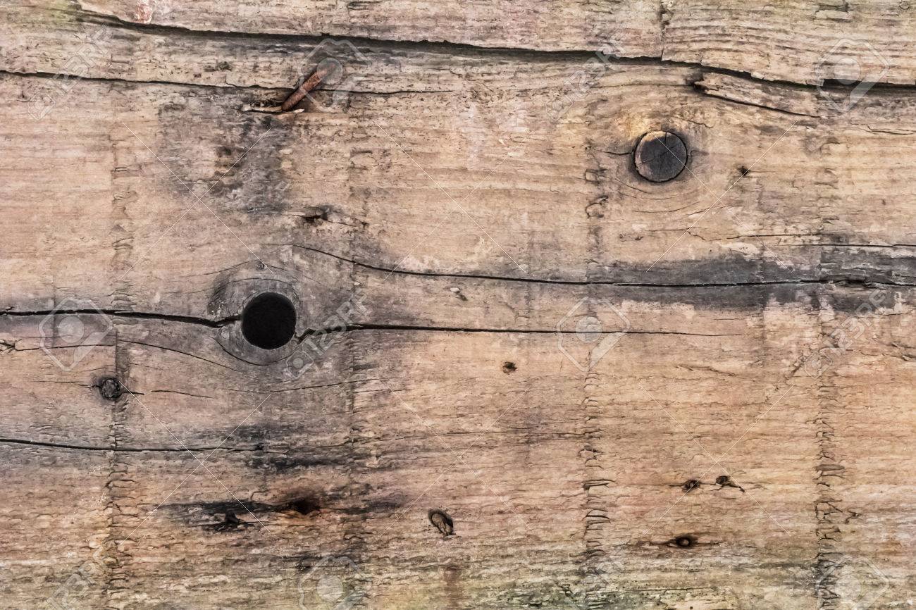 old weathered rotten plank with wood knots lateral cracks