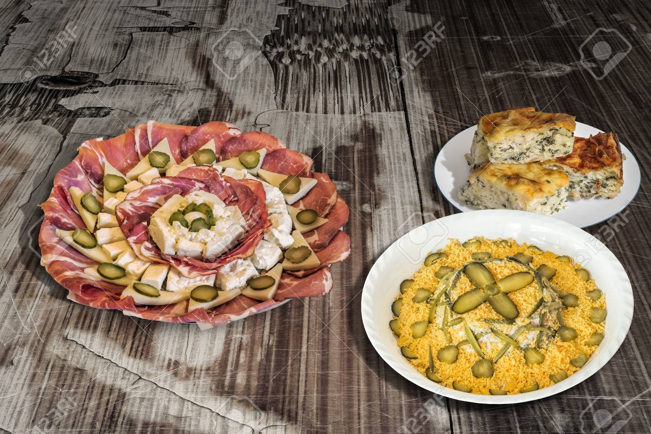 ロシアのサラダ前菜おいしい料理メゼとほうれん草チーズ パイ Zeljanica の古いひびの入った木製のテーブル の写真素材 画像素材 Image