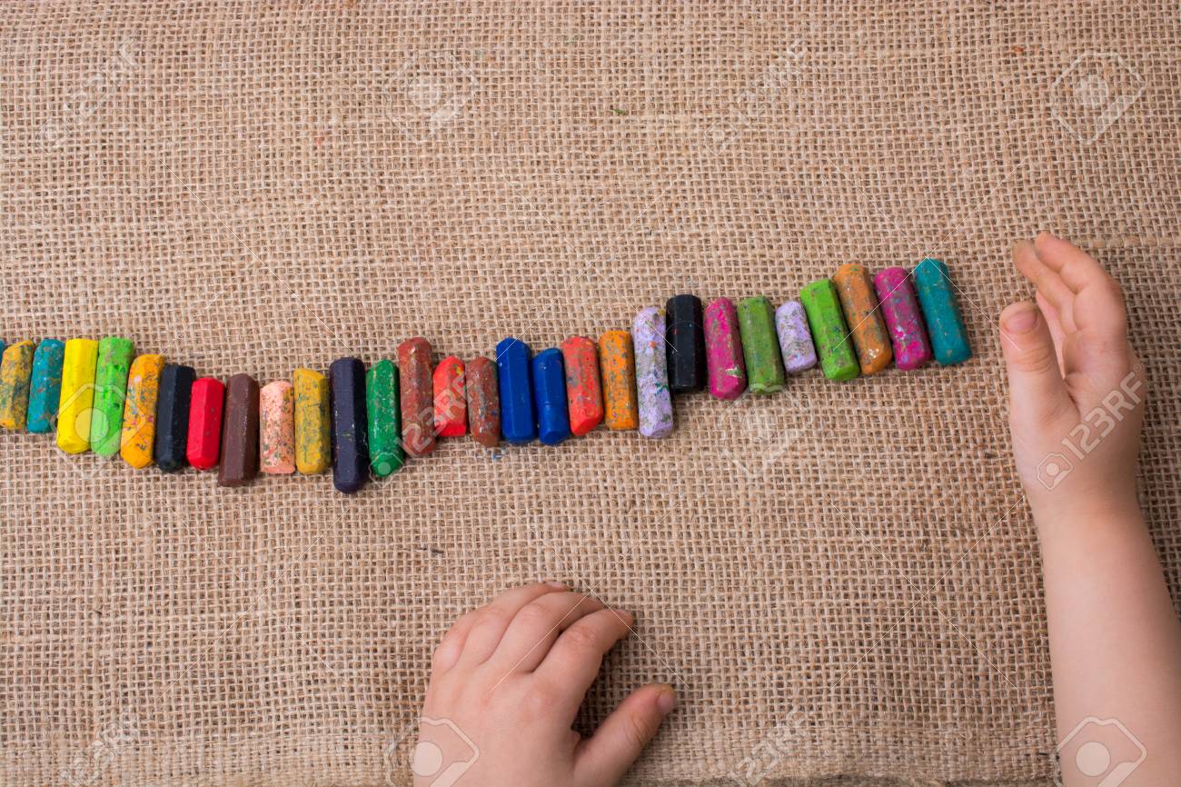 toddlers hand putting crayons in line on canvas stock photo picture
