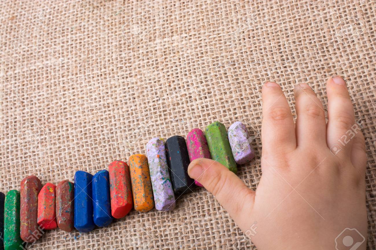 toddlers hand putting crayons in line on canvas stock photo picture