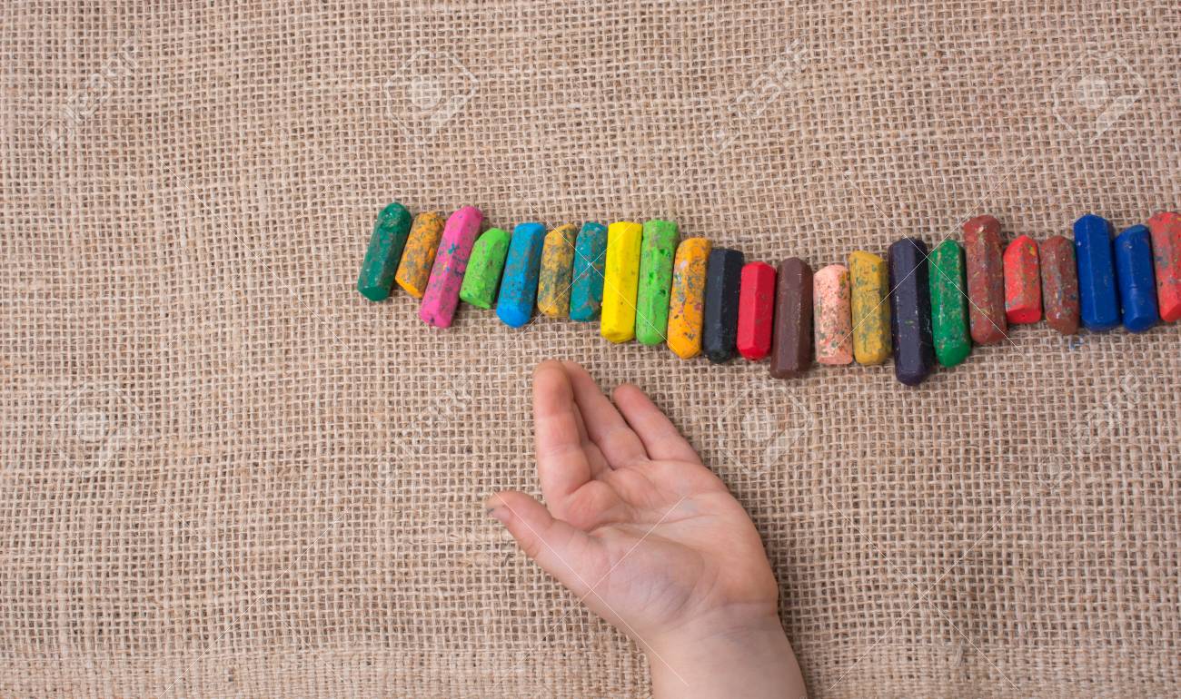 toddlers hand putting crayons in line on canvas stock photo picture