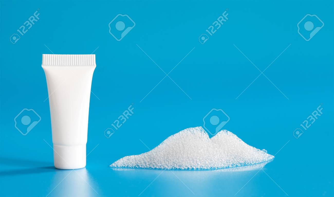 青の背景に白い化粧品のチューブ石鹸の泡泡 抽象的なシャンプー プラスチック容器 空のパッケージ デザイン の写真素材 画像素材 Image