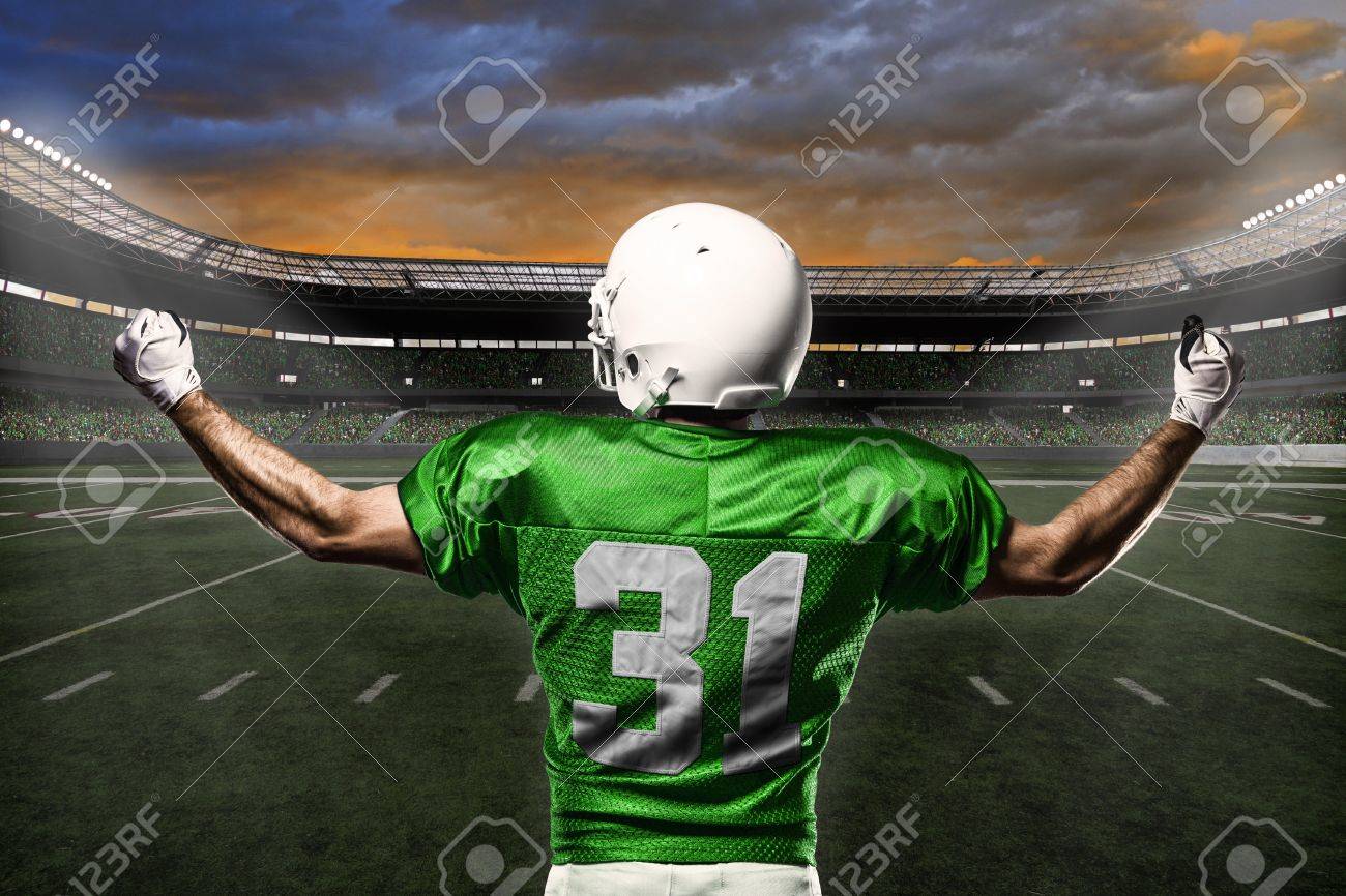 Football Player with a green uniform celebrating with the fans. - 21782159 Football Player with a green uniform celebrating with the fans. - 21782159