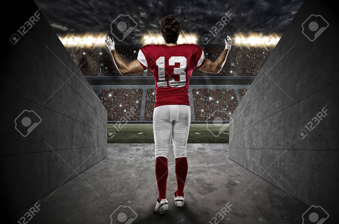 Football Player with a red uniform walking out of a Stadium tunnel. - 35218291 Football Player with a red uniform walking out of a Stadium tunnel. - 35218291