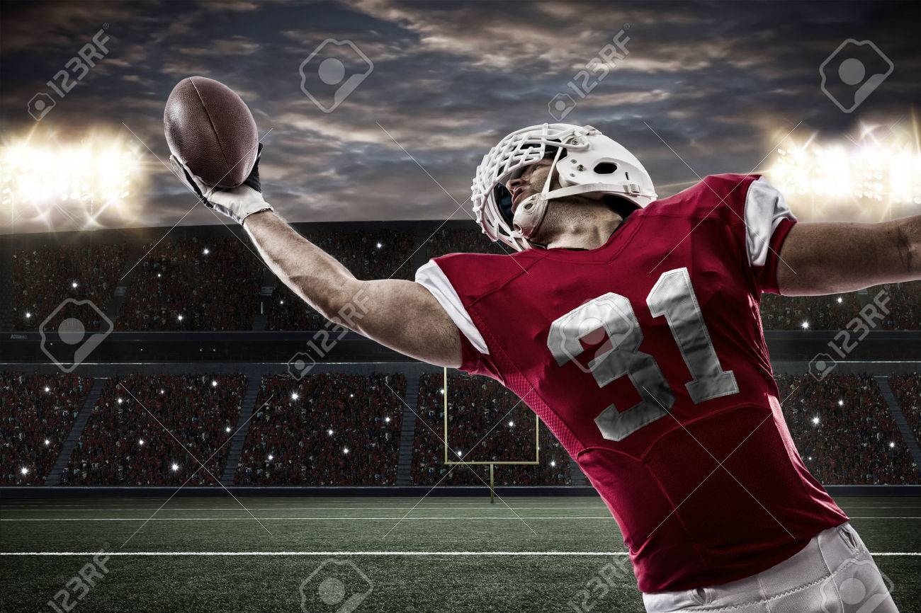 Football Player with a red uniform catching a ball on a stadium.. - 35218342 Football Player with a red uniform catching a ball on a stadium.. - 35218342