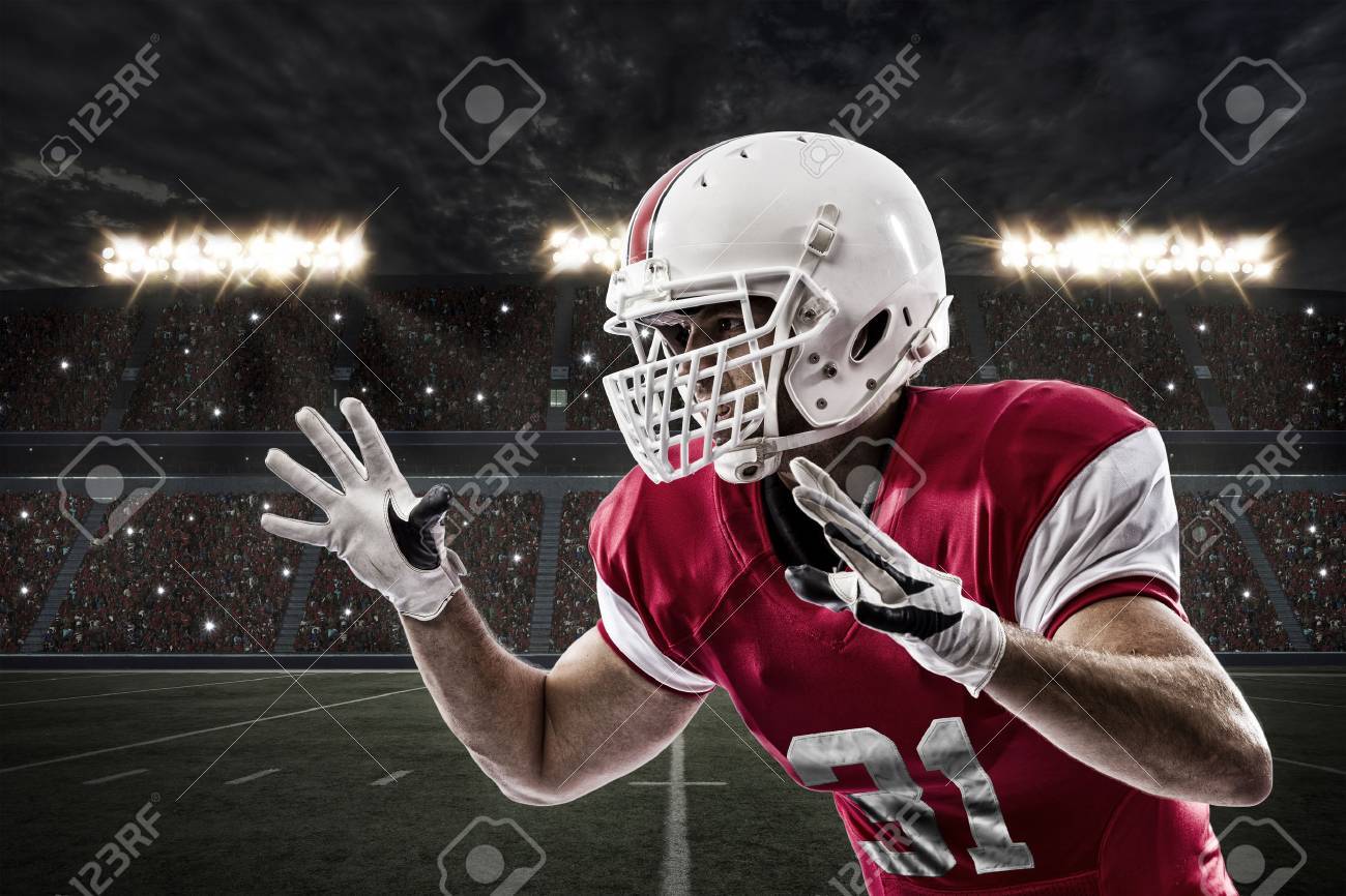 Football Player with a red uniform making a tackle on a Stadium. - 35219261 Football Player with a red uniform making a tackle on a Stadium. - 35219261