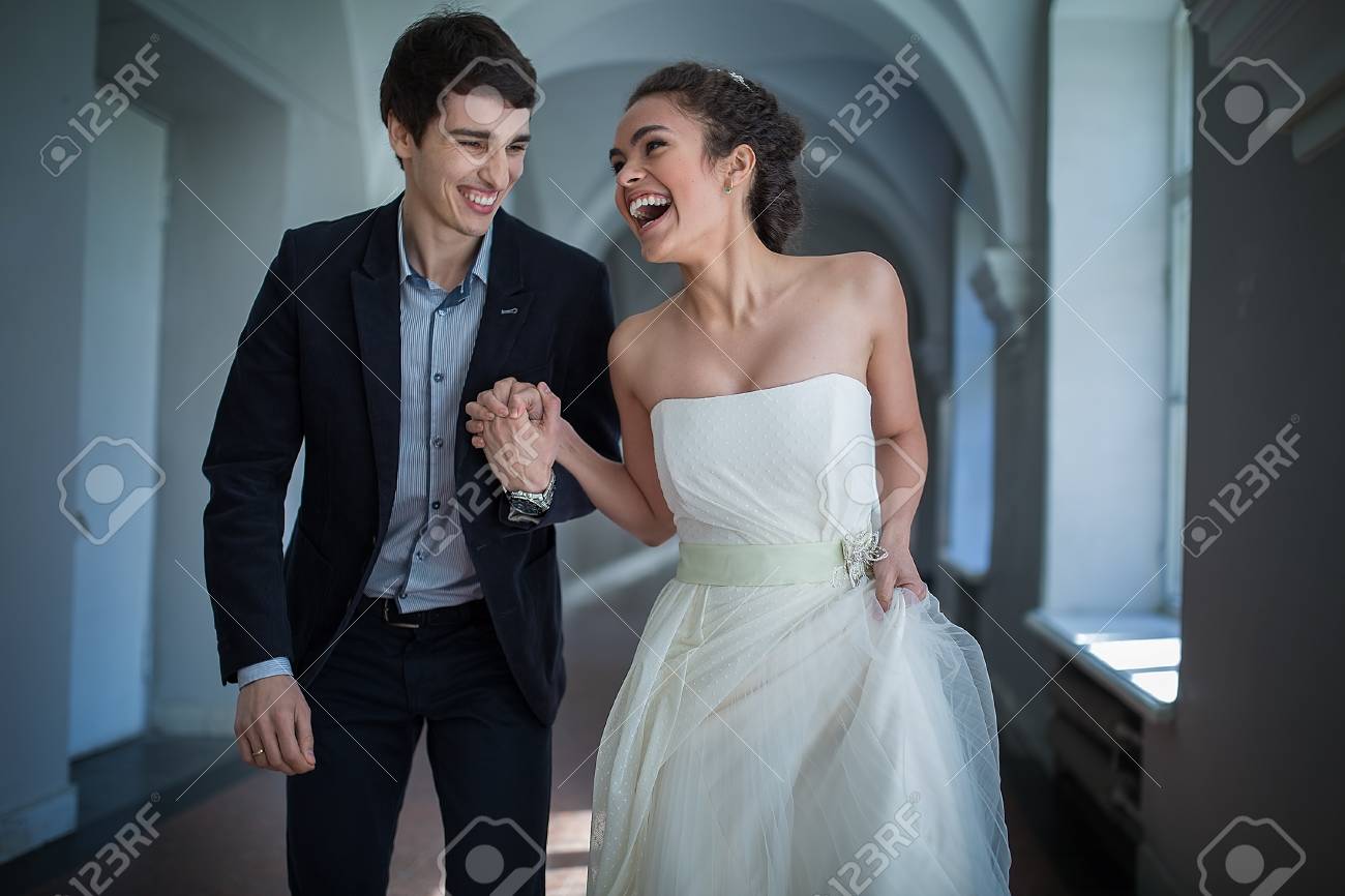행복한 커플을 장난스럽게 손을 잡고 긴 복도 내려 간다. 로열티 무료 사진, 그림, 이미지 그리고 스톡포토그래피. Image  40634189
