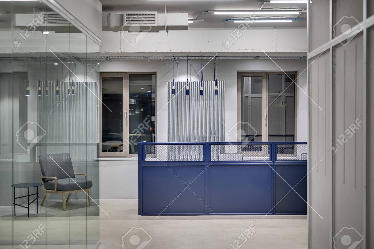 büro im loft stil glass blaue metallempfangsrack mit sesseln auf den fenstern hintergrund in einem loftstil büro grauen wänden der linken seite befindet sich ein grauer büro im loft stil glass blaue metallempfangsrack mit sesseln auf den fenstern hintergrund in einem loftstil büro grauen wänden der linken seite befindet sich ein grauer