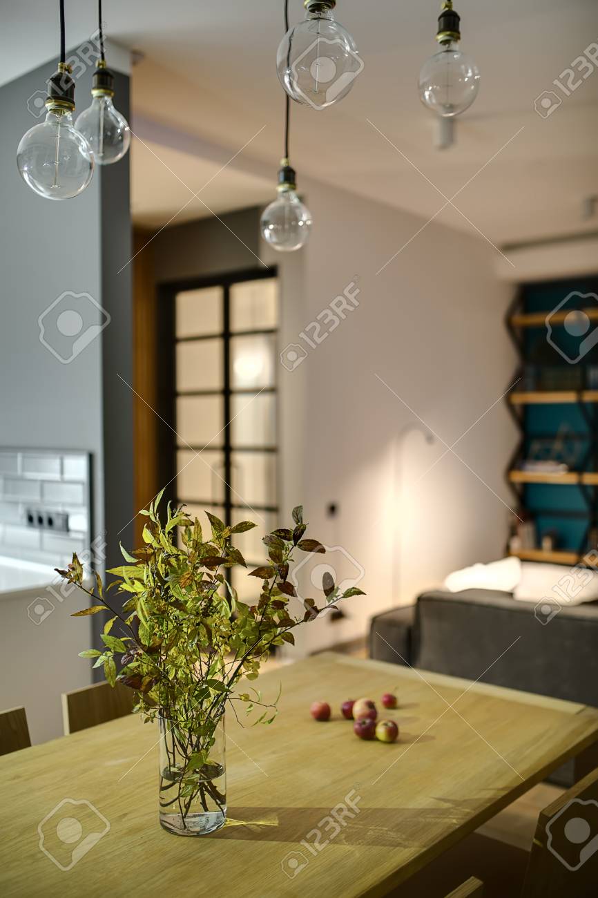 Green Branches In A Vase And Apples On The Wooden Table With