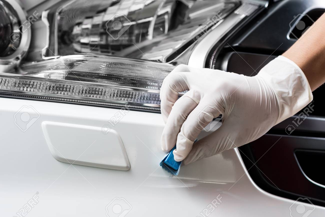 カーディテー シリーズ 白い車フロント バンパー塗装をコーティングの手のクローズ アップ の写真素材 画像素材 Image