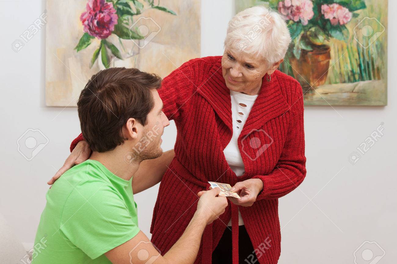 grandma giving pocket money for her grandson stock photo picture