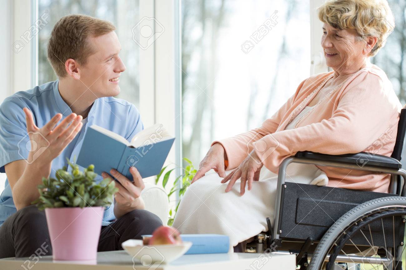 Male care assistant reading senior woman book - 38199425 Male care assistant reading senior woman book - 38199425
