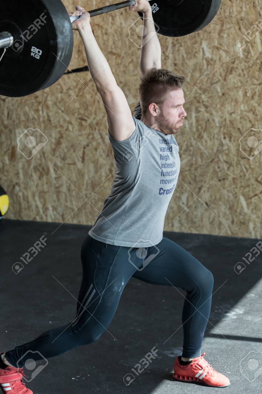 重いトレーニング中にバーベルを持ち上げる運動の男の写真素材・画像