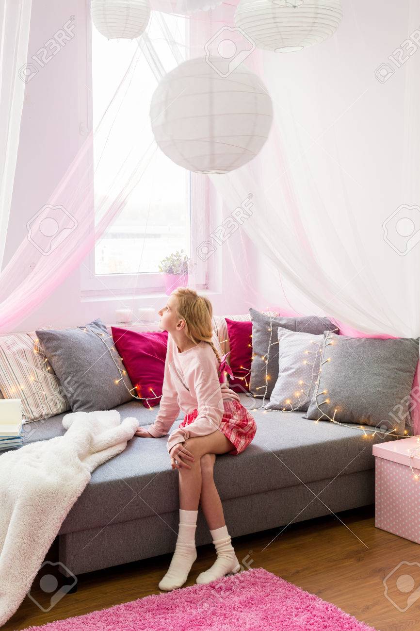 彼女のスタイリッシュな部屋でソファーに座っていたかわいい女の子 の写真素材 画像素材 Image