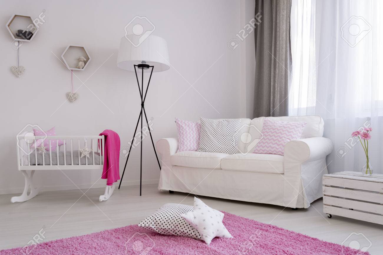 Esquina De La Habitacion De Un Bebe Con El Sofa Blanco Cuna Y Una Alfombra De Color Rosa Suave Y Esponjosa Fotos Retratos Imagenes Y Fotografia De Archivo Libres De Derecho Image