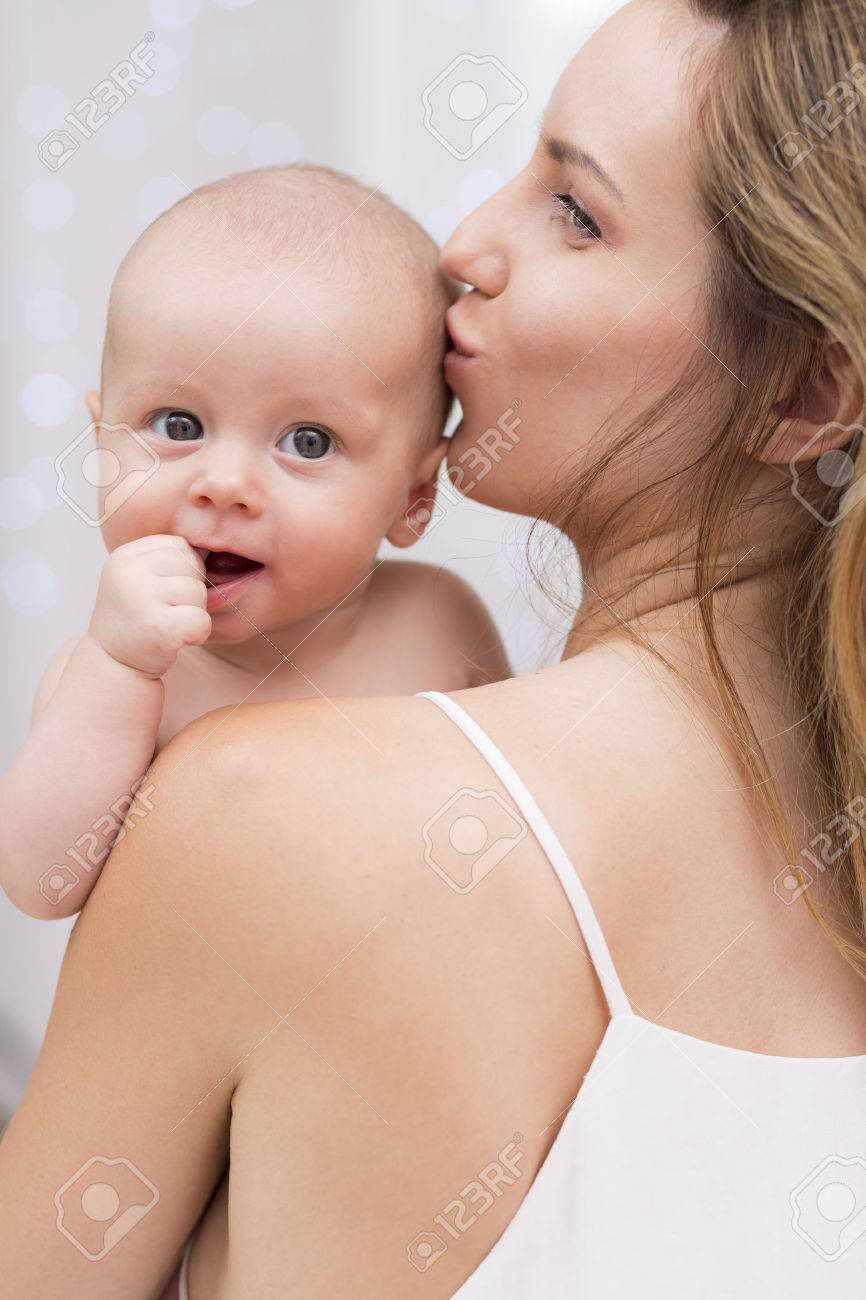 美人女の赤ちゃんを保持し 彼女の頭にキスのショットをトリミング の写真素材 画像素材 Image