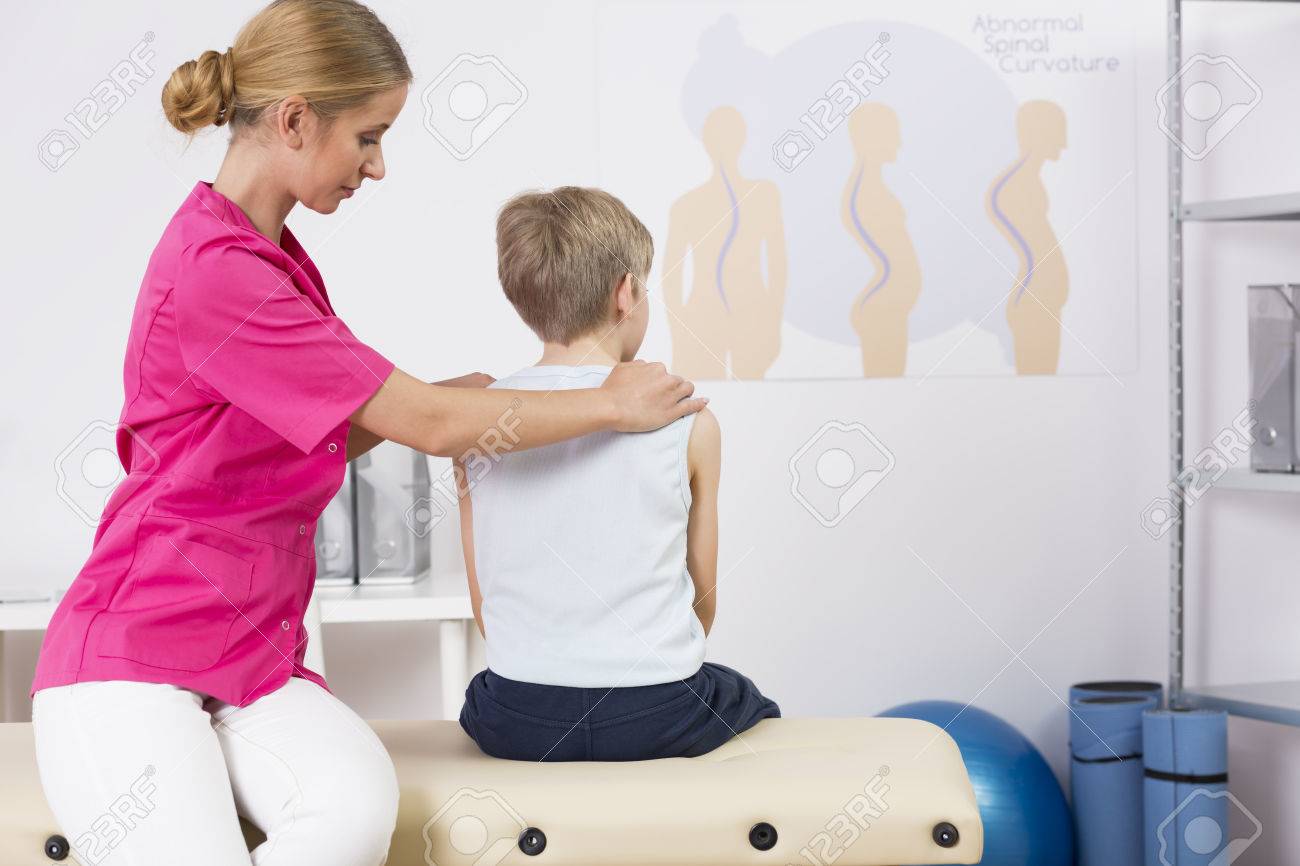 Physiotherapist correcting body posture of a small boy - 60587106 Physiotherapist correcting body posture of a small boy - 60587106