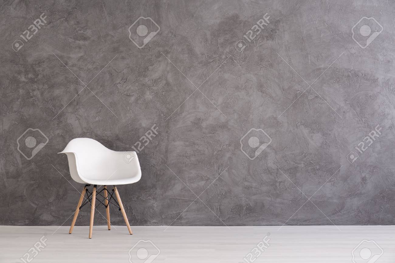 White plastic chair on a background of a gray concrete wall - 60771994 White plastic chair on a background of a gray concrete wall - 60771994