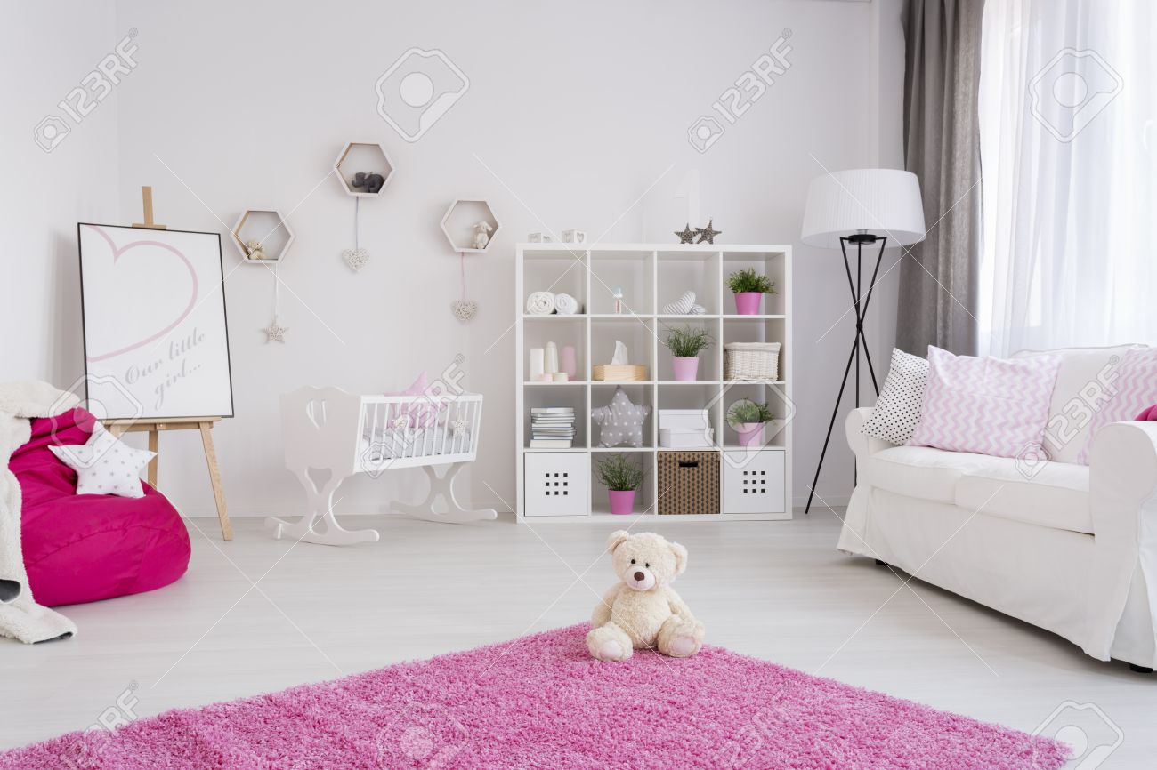 Habitacion Del Bebe En Colores Pastel Con Un Comodo Sofa Caja De Libro Cuna Y Oso De Peluche Sentado En Una Alfombra De Color Rosa Fotos Retratos Imagenes Y Fotografia De Archivo